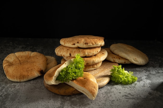 Gâteaux moelleux pitas sur une planche de bois sur fond sombre