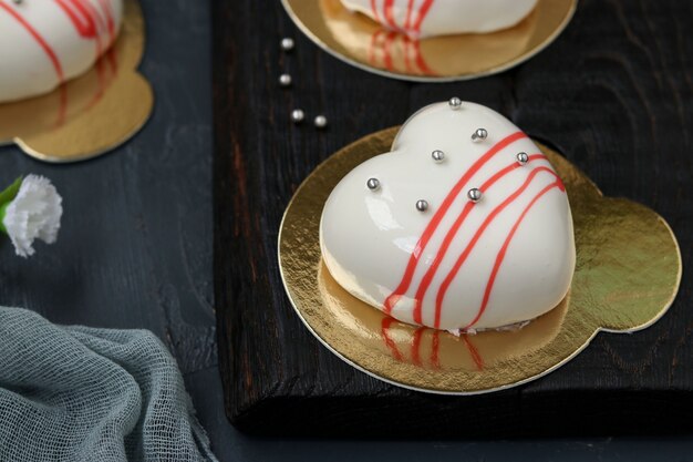 Gâteaux mousse maison Coeurs avec glaçage miroir blanc sur fond sombre