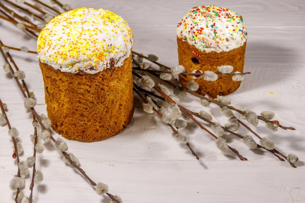 Gâteaux de Pâques avec des branches de saule sur une table en bois blanc