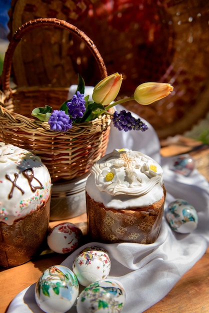 Gâteaux de Pâques oeufs et tulipes jaunes et fleurs violettes dans un panier le jour de Pâques