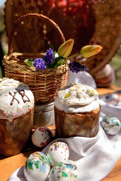 Gâteaux de Pâques et tulipes jaunes et fleurs violettes dans un panier le jour de Pâques