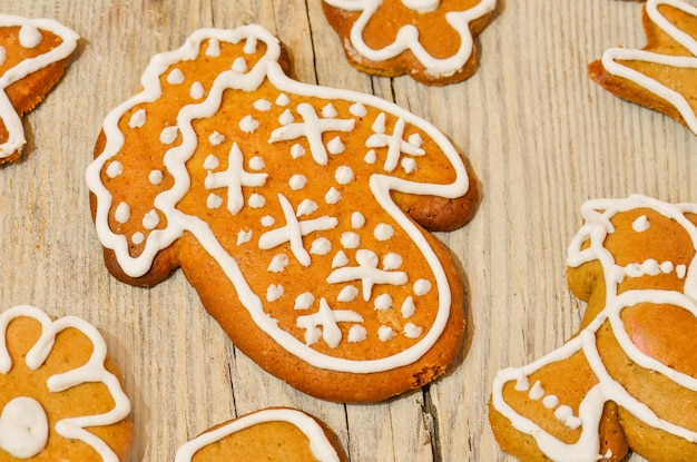 Gâterie de Noël traditionnelle. Savoureux biscuits au pain d'épice mitaines sur fond de bois. Biscuits de Noël maison