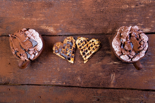 Gaufre au chocolat chaud avec guimauve sur fond en bois en forme de coeur belge.