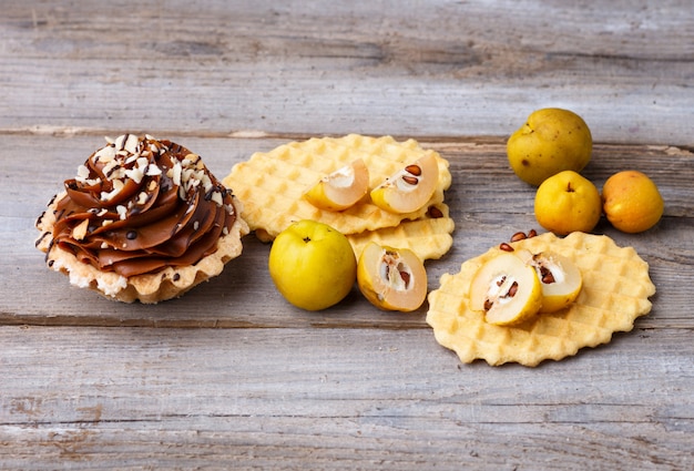 Gaufre sucrée et gâteau à la crème sur un fond en bois