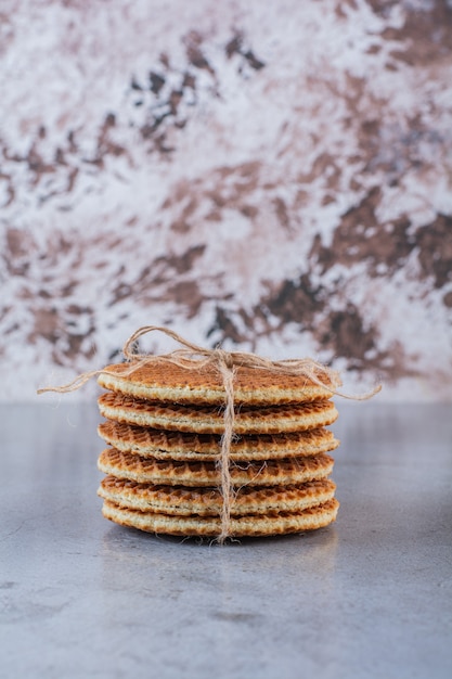 Gaufres au caramel attachées avec un arc de jute isolé sur une surface en pierre