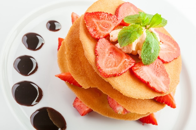 Gaufres au caramel, crème fouettée et fraises isolées