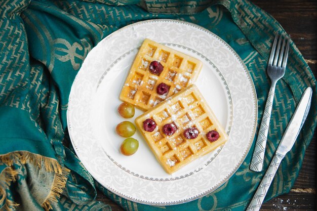 Des gaufres belges aux baies sont versées avec de la confiture