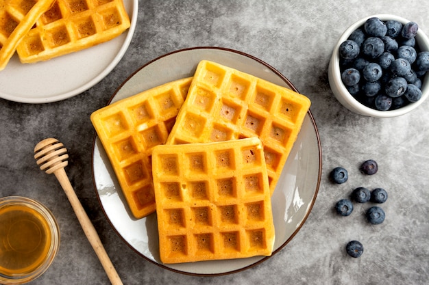 Gaufres belges aux myrtilles et au miel pour le petit déjeuner. Délicieuse pâtisserie maison.