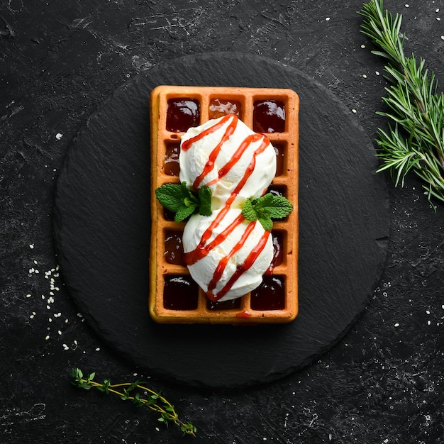 Gaufres belges avec crème glacée confiture de fraises et menthe Dessert Sur une plaque en pierre noire