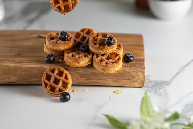 Gaufres belges faites maison avec myrtille et miel sur table en marbre verticale