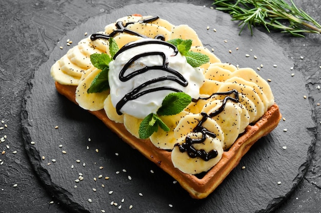 Gaufres belges avec glace à la banane et dessert au chocolat Sur une assiette en pierre noire