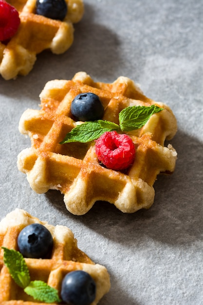 Gaufres belges traditionnelles aux bleuets et framboises sur pierre grise