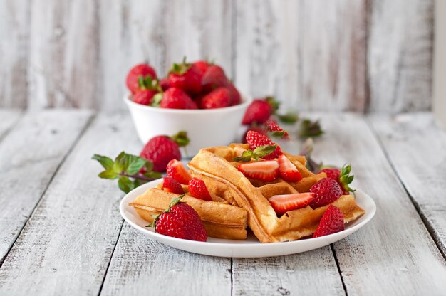 Gaufres de Belgique aux fraises et menthe sur plaque blanche