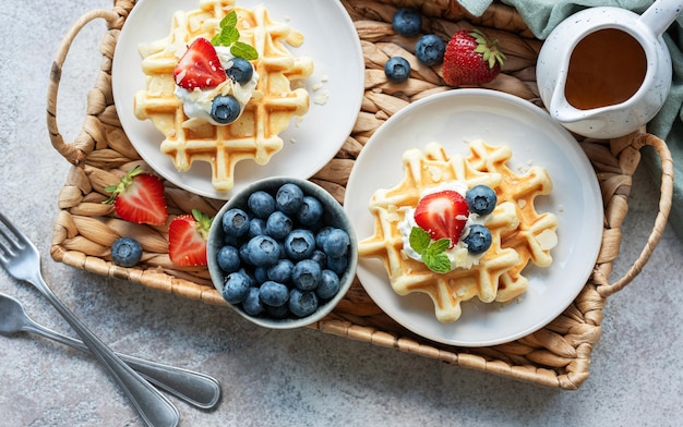 Des gaufres fraîchement cuites avec des fraises et des bleuets