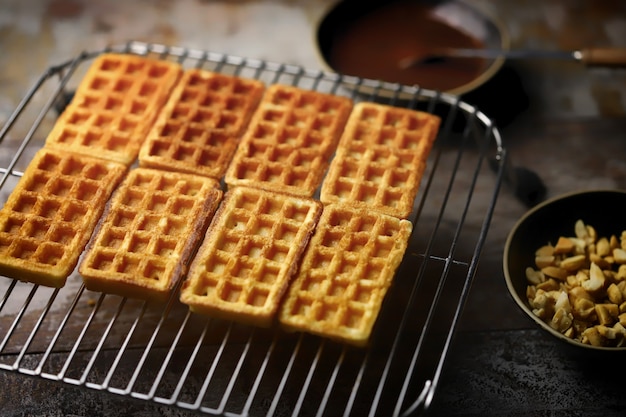 Gaufres fraîches sur une grille, chocolat et noix.