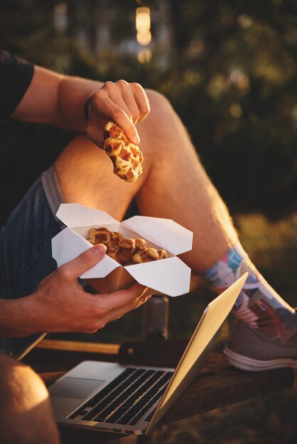 Gaufres fraîches tenant dans les mains, repas américain à emporter.