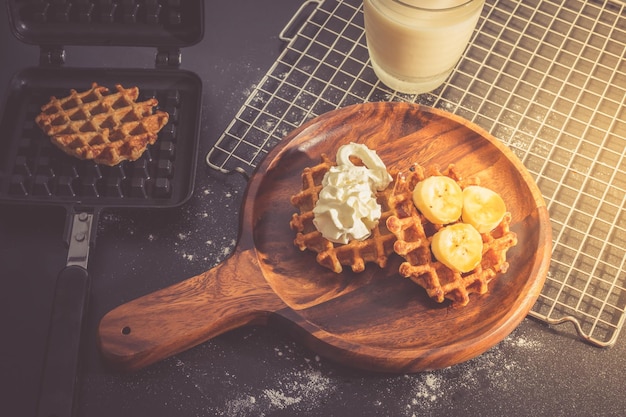 Gaufres maison sucrées avec des tranches de banane sur une plaque en bois