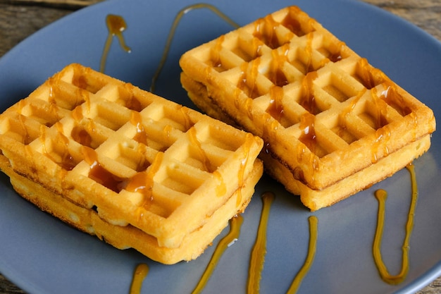 Gaufres molles dans une assiette versée avec du miel