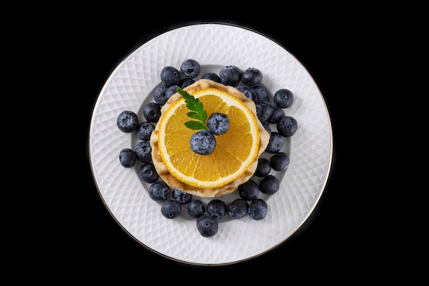 Gaufres à l'orange et aux bleuets frais sur une assiette de service blanche.