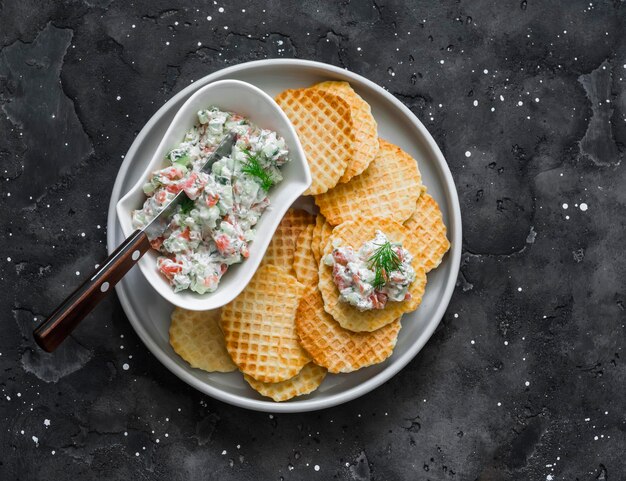 Gaufres de pommes de terre croustillantes et concombre de fromage à la crème de saumon étalés sur fond sombre Vue de dessus Délicieuses tapas apéritives