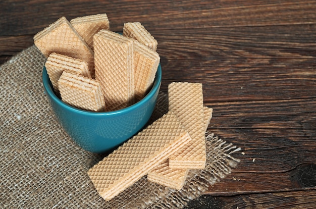 Gaufrettes dans un bol turquoise sur la vieille table en bois