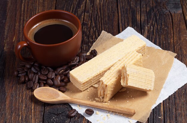 Photo gaufrettes sucrées et tasse de café chaud pour le petit déjeuner sur une table en bois sombre