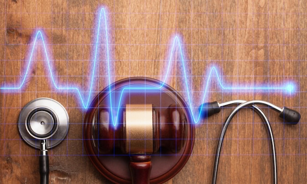 Photo gavel et stéthoscope sur fond de bois, photo symbole pour maladresse et erreur médicale