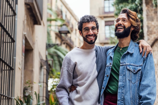 Gay male couple embrassant souriant heureux dans la rue