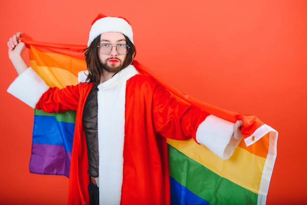 Gay Man habillé en Père Noël tenant un drapeau multicolore