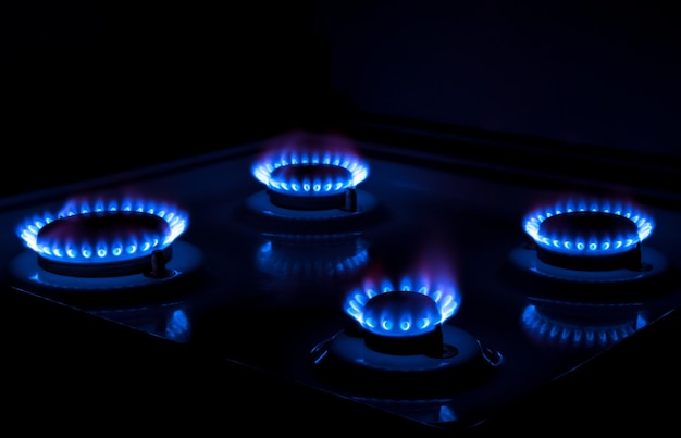 Gaz naturel brûlant des flammes bleues sur fond noir