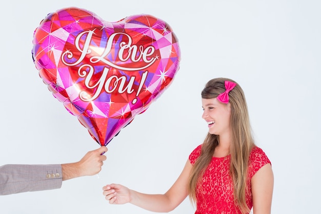 Geek hipster offrant un ballon de forme de coeur rouge à sa petite amie