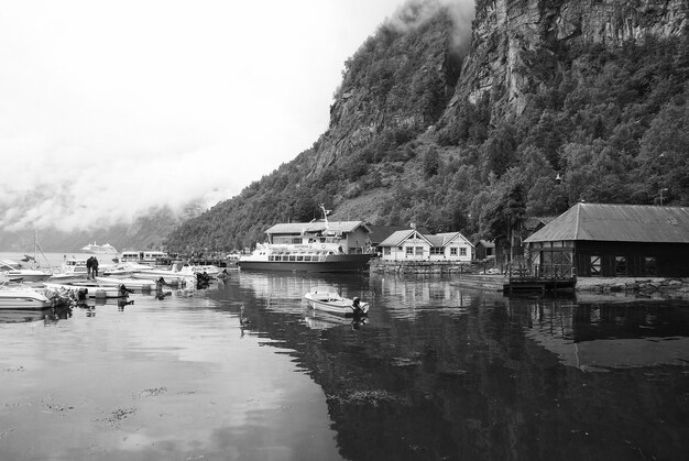 Geiranger Norvège 25 janvier 2010 maisons de village bateaux dans le port de mer sur le paysage de montagne Navires de transport par eau Destination de voyage Tourisme Voyage de vacances Wanderlust