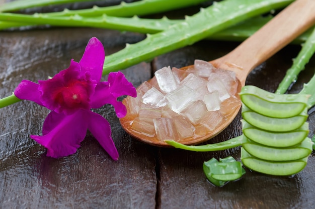 Gel d&#39;aloès frais à la cuillère et fleur sur bois