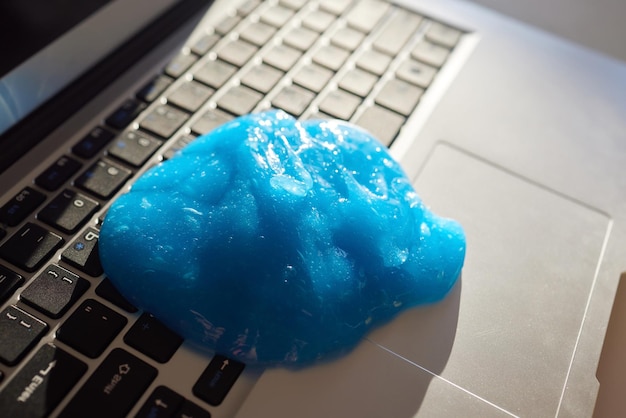 Gel bleu doux nettoyant la poussière sur le clavier Concept nettoyant le clavier de votre ordinateur Nettoyage de bureau