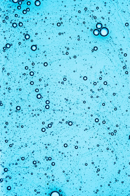 Gel cosmétique bleu liquide sur un écran numérique de microscope ou d'eau pétillante