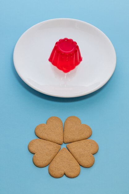 Gélatine de fraise sur une plaque blanche avec des biscuits en forme de coeur