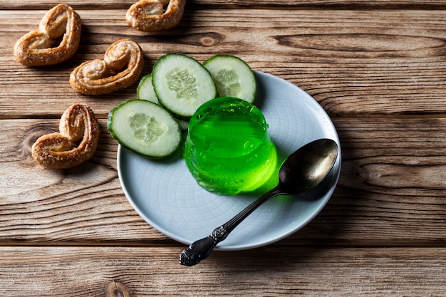 Gelée de concombre sur une soucoupe, avec des cookies sur une table en bois