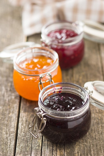 Photo gelée de confiture fruitée en pot sur une vieille table en bois