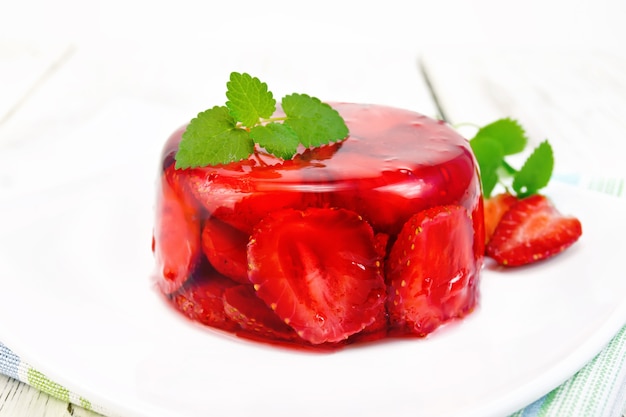 Gelée de fraise à la menthe et aux baies dans une assiette sur une serviette sur fond de planches de bois