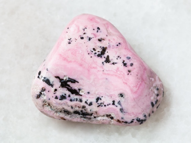 Gemme polie de rhodochrosite sur le blanc