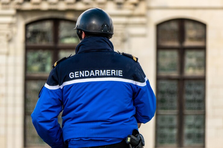 Photo gendarme français à cheval vu de derrière avec l'inscription gendarme sur sa veste
