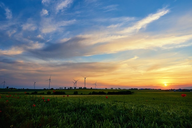 Générateur de turbine de moulin à vent contre le beau ciel de coucher du soleil dans la campagne concept de renouvellement propre