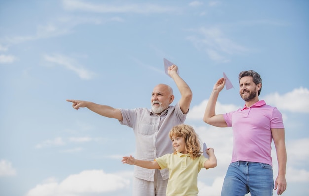 Génération d'hommes grand-père père et petit-fils jouant avec un avion jouet en plein air sur ciel garçon rêve de b