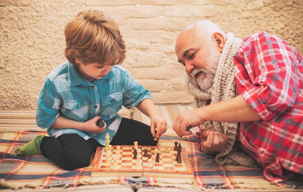 Générations échec et mat loisirs d'échecs grand-père avec petit-fils sur un jeu d'échecs