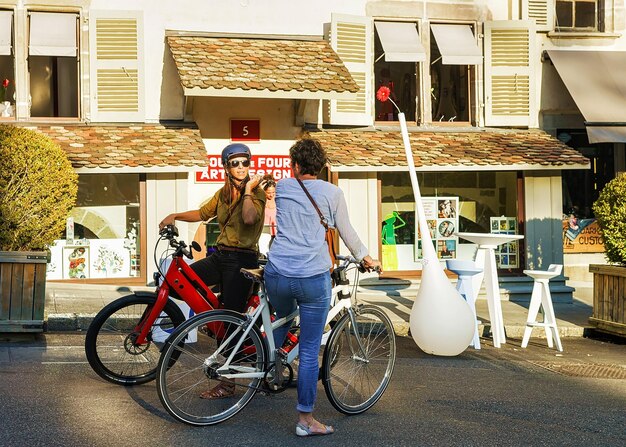 Genève, Suisse - 30 août 2016 : Des femmes à bicyclette se parlent à la place du Bourg-Four dans la vieille ville de Genève, Suisse