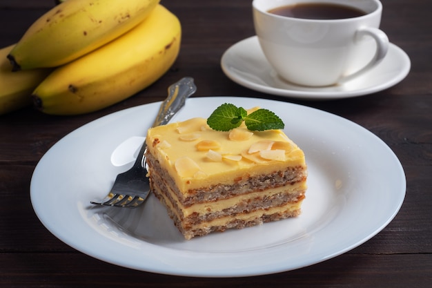 Génoise aux bananes aux noix et à la menthe. Délicieux dessert sucré pour le thé, fond en bois foncé.