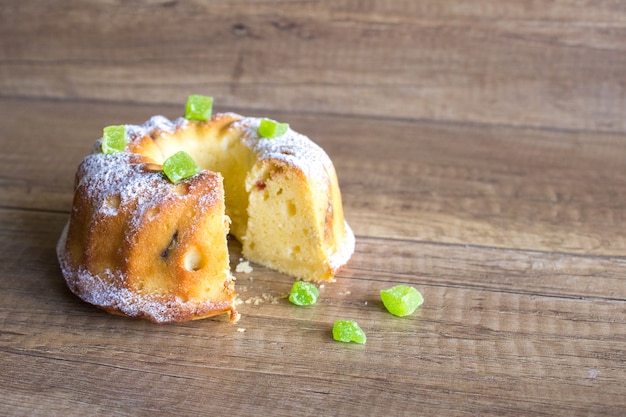 Génoise aux pommes et sucre glace sur fond en bois