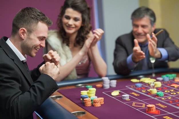 Gens acclamant l&#39;homme au jeu de craps