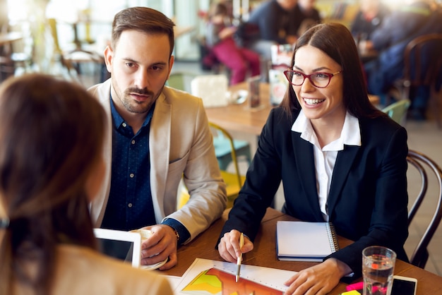 Gens d'affaires au café-bar en conversation.