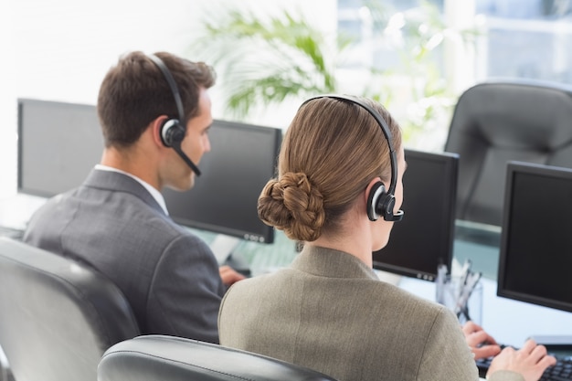 Gens d&#39;affaires avec des casques en utilisant des ordinateurs